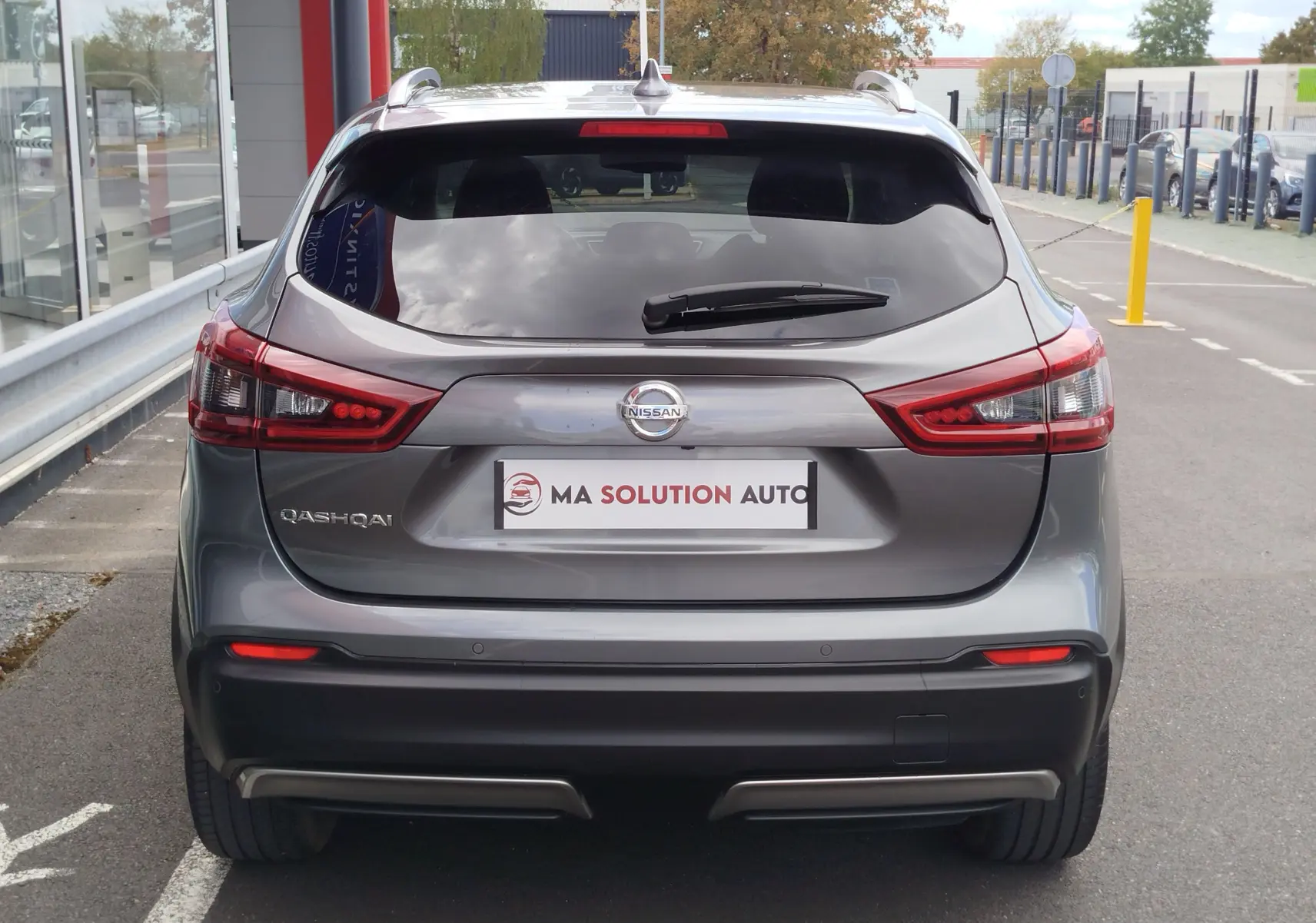 Vue arrière d'un Nissan Qashqai gris Squale 2021 avec feux arrière LED et logo Nissan bien visibles.