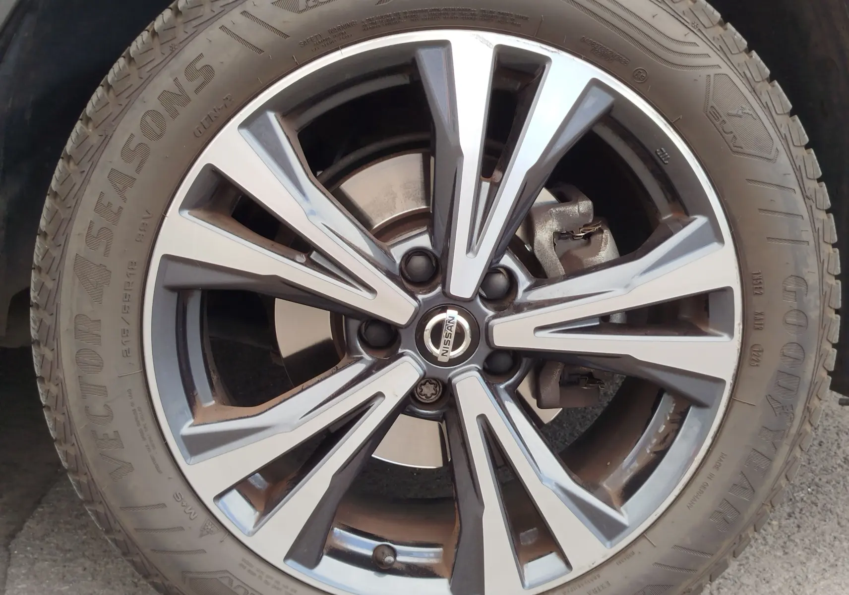 Gros plan sur la jante alliage bicolore du Nissan Qashqai Gris Squale, mettant en valeur le logo central et le pneu Goodyear.