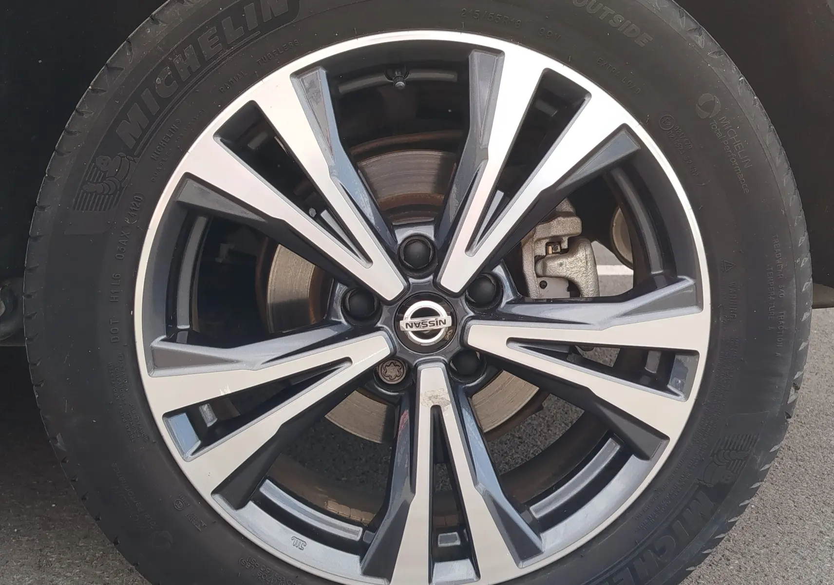 Gros plan sur la jante alliage bicolore du Nissan Qashqai 1.5 dCi 2019 en gris Squale avec logo central Nissan visible.