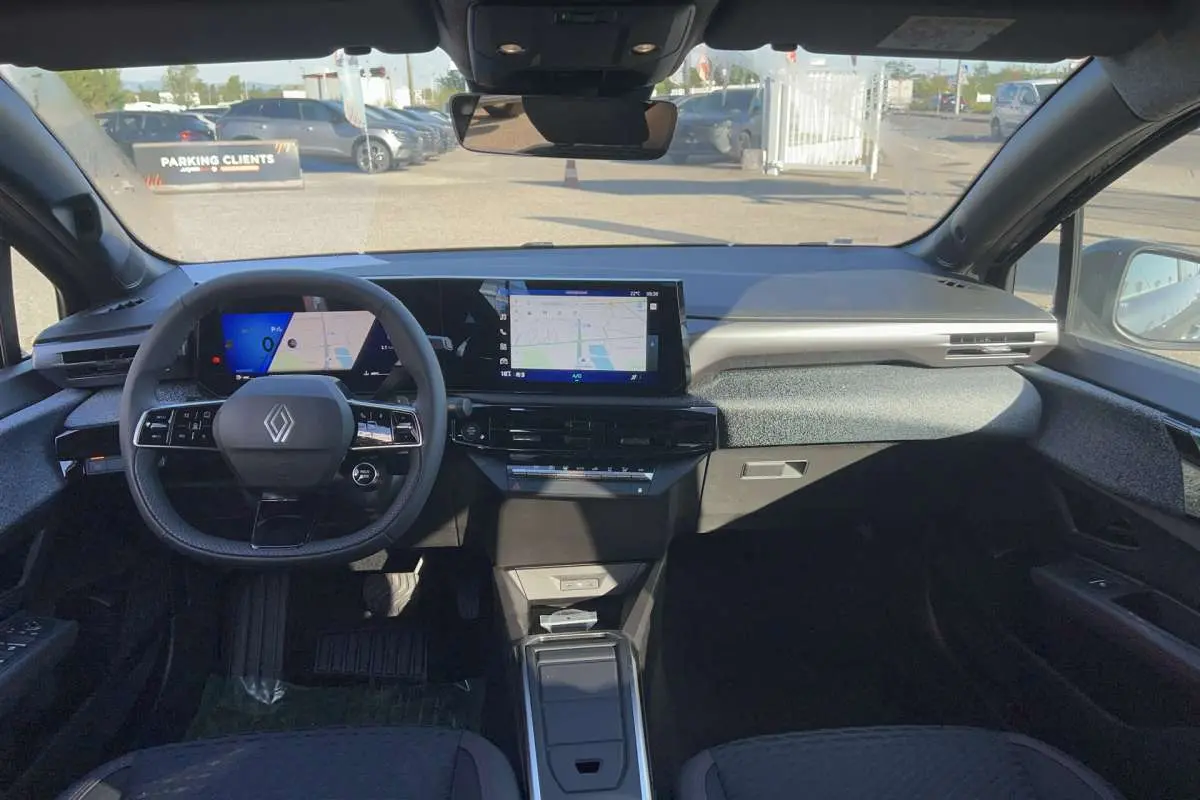 Vue intérieure avant de la Renault Clio 6 TCE 115 EDC Techno, tableau de bord moderne avec écran tactile et volant multifonctions.