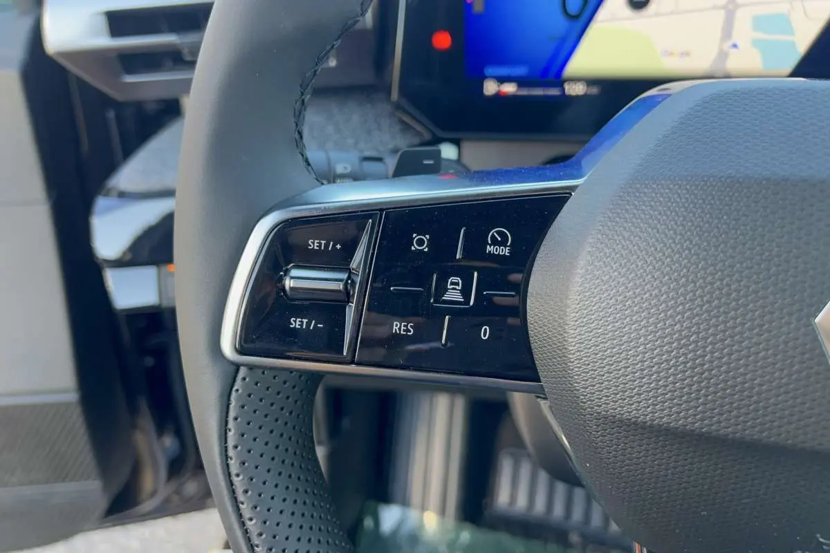 Gros plan sur les commandes multifonctions côté gauche du volant textile noir de la Renault Clio 6 TCE 115 EDC TECHNO.