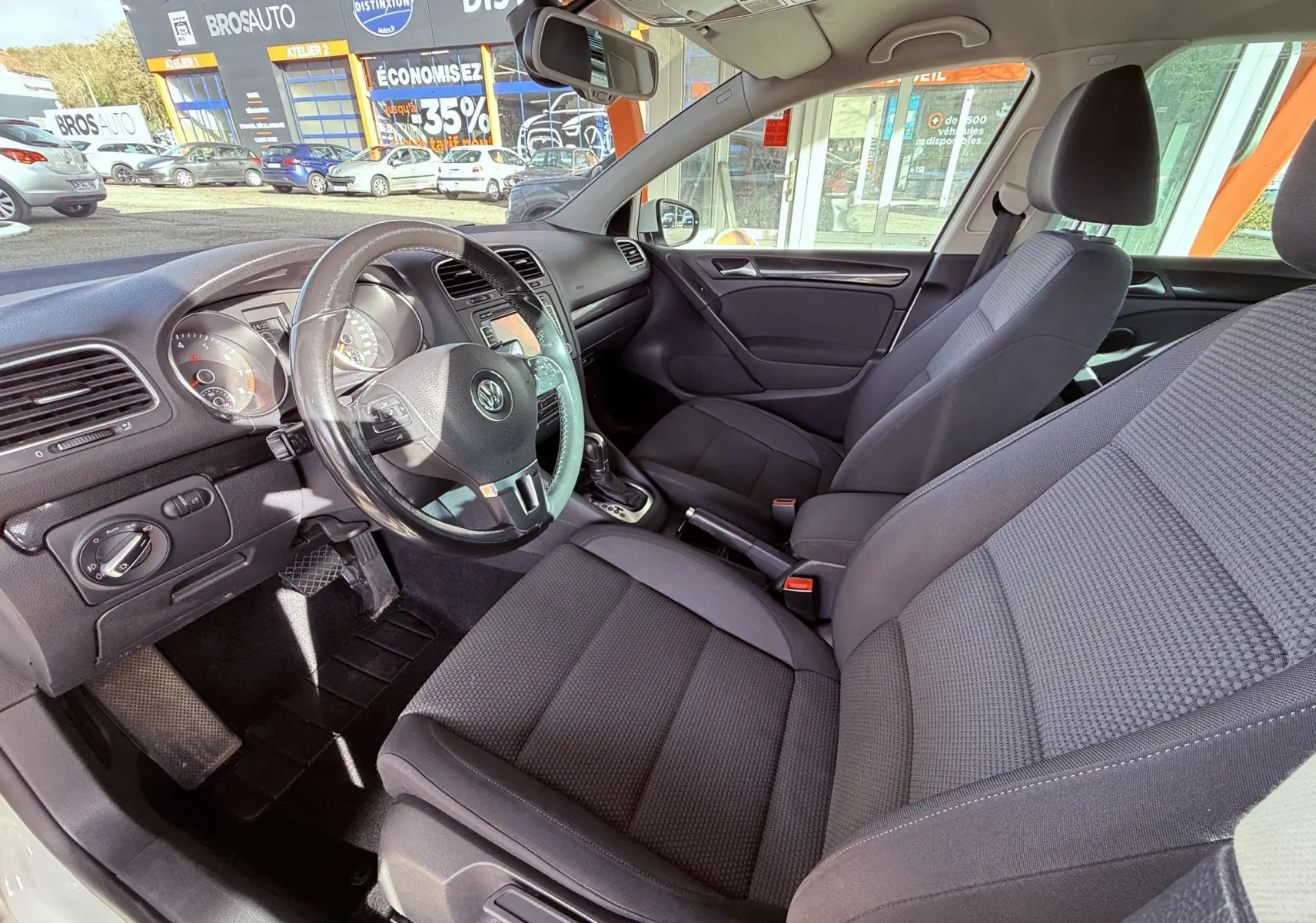 Intérieur avant gris foncé d'une Volkswagen Golf 1.4 TSI 2012, vue côté conducteur avec volant et tableau de bord visibles.