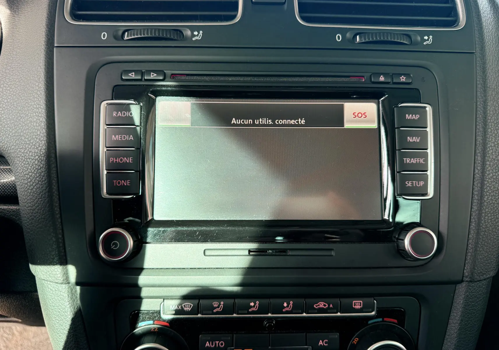 Écran central tactile de la Volkswagen Golf 1.4 TSI 2012 avec commandes radio et climatisation visibles en gros plan.