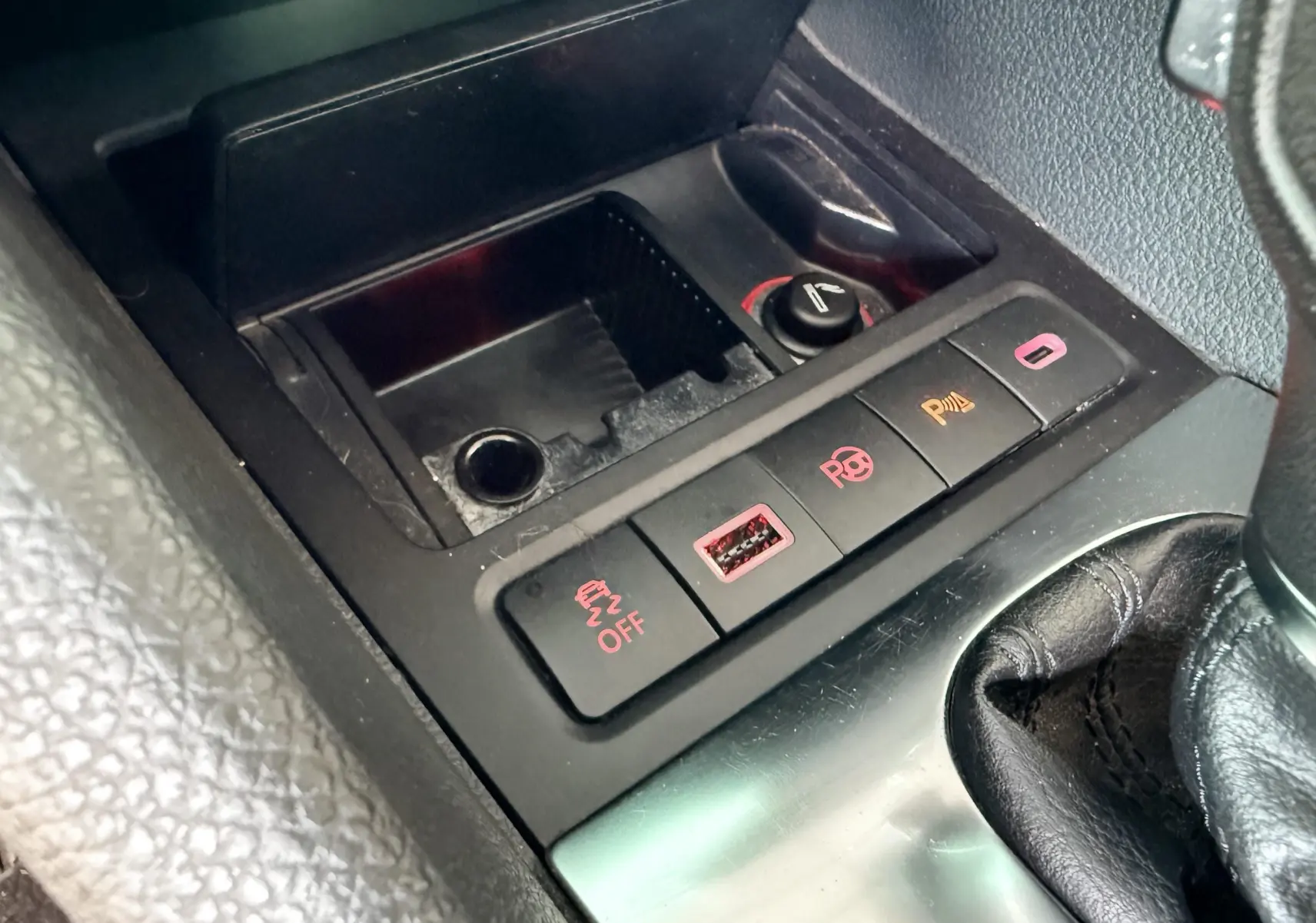 Gros plan sur la console centrale d'une Volkswagen Golf blanche 2012, montrant les boutons de contrôle et prise USB.