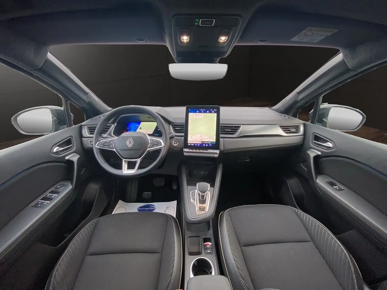 Vue intérieure avant du Renault Symbioz 2025 noir étoile, avec tableau de bord numérique et écran tactile vertical central.