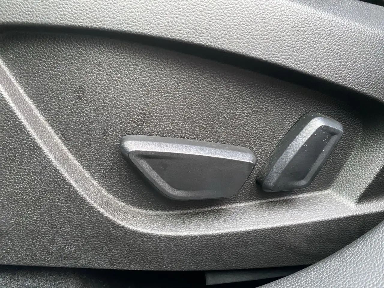 Gros plan sur les commandes de réglage électrique du siège côté conducteur du Renault Symbioz noir étoile 2025.