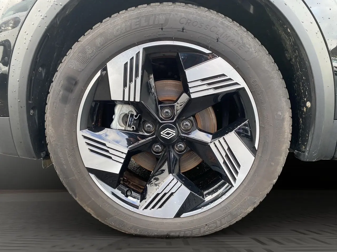 Gros plan sur la roue avant gauche noire étoile du Renault Symbioz 2025 avec jante bicolore au design moderne.