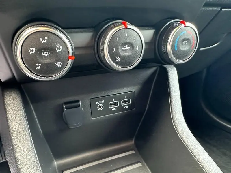 Détail du tableau de bord de la Renault Clio 2023, montrant les commandes de climatisation et ports USB en gros plan.