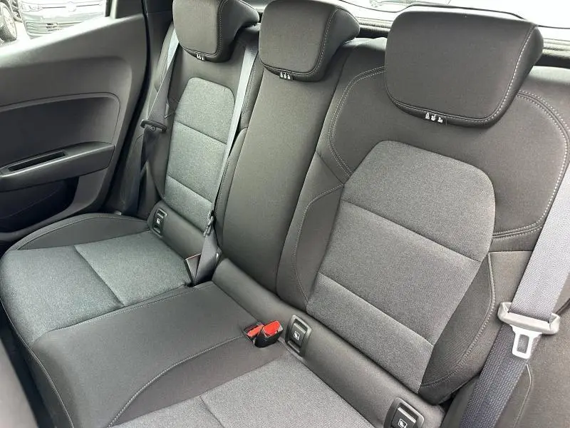 Vue intérieure des sièges arrière gris foncé de la Renault Clio 2023, avec ceintures de sécurité et appuie-têtes visibles.