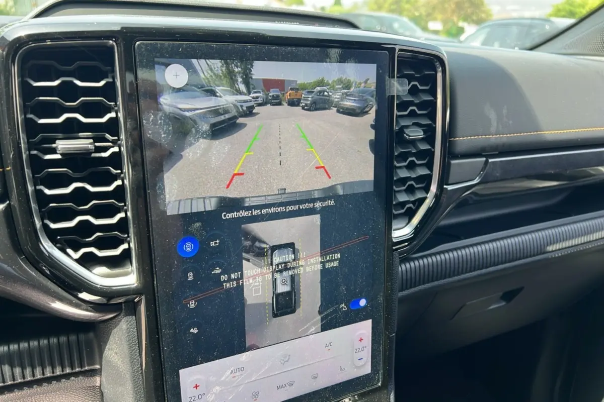 Vue intérieure centrée sur l'écran tactile du Ford Ranger noir agate montrant la caméra de recul et le tableau de bord.