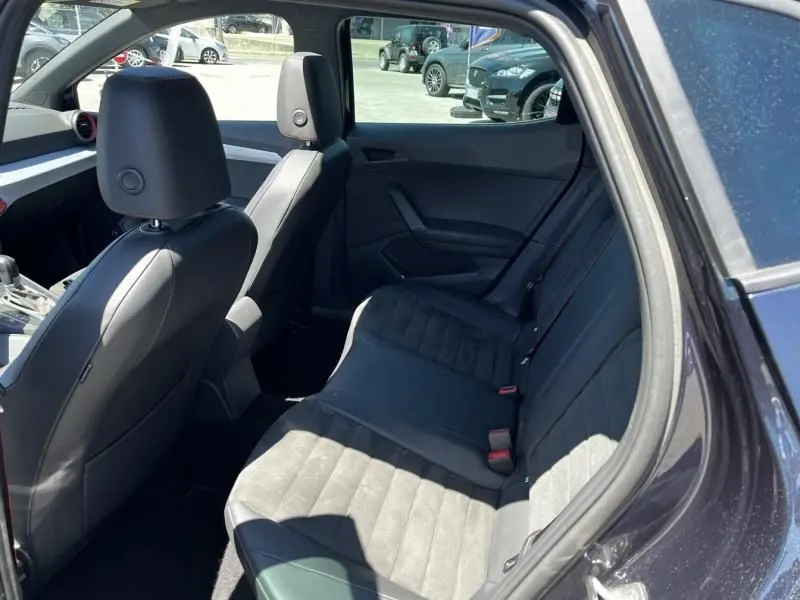 Vue intérieure côté arrière droit de la SEAT Ibiza 1.5 TSI 150 cv FR Xclusive 2022, sièges en tissu et cuir noir.