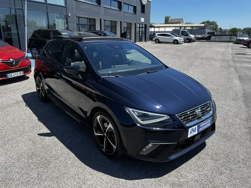 SEAT Ibiza 1.5 TSI FR Xclusive bleu foncé métal vue 3/4 avant avec jantes noires et phares LED allumés.
