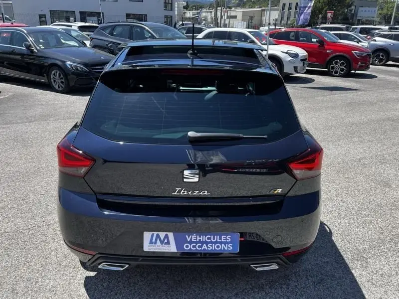 Vue arrière d'une SEAT Ibiza 1.5 TSI FR Xclusive bleu foncé métal avec double sortie d'échappement et toit ouvrant.
