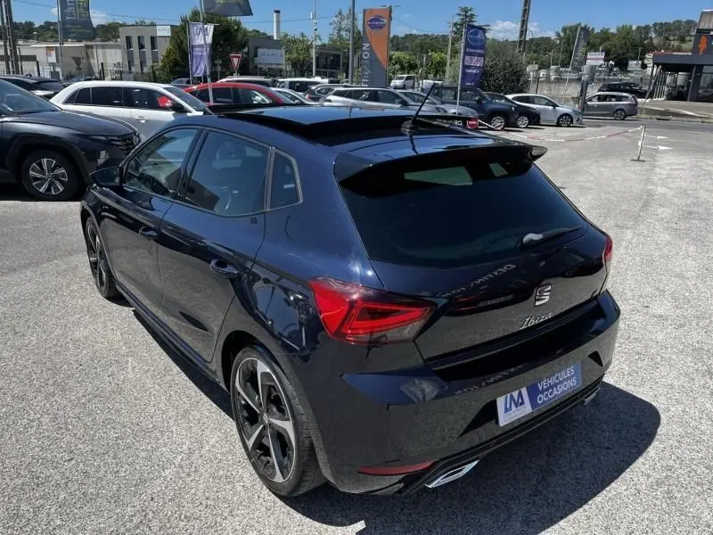 Vue 3/4 arrière droite d'une SEAT Ibiza 1.5 TSI 150 cv FR Xclusive bleu foncé métal avec jantes sport et toit ouvrant.