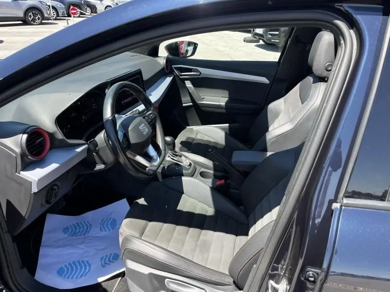 Intérieur de SEAT Ibiza 1.5 TSI 150 FR Xclusive 2022 en bleu foncé, vue côté conducteur avec sièges sport et volant multifonction.