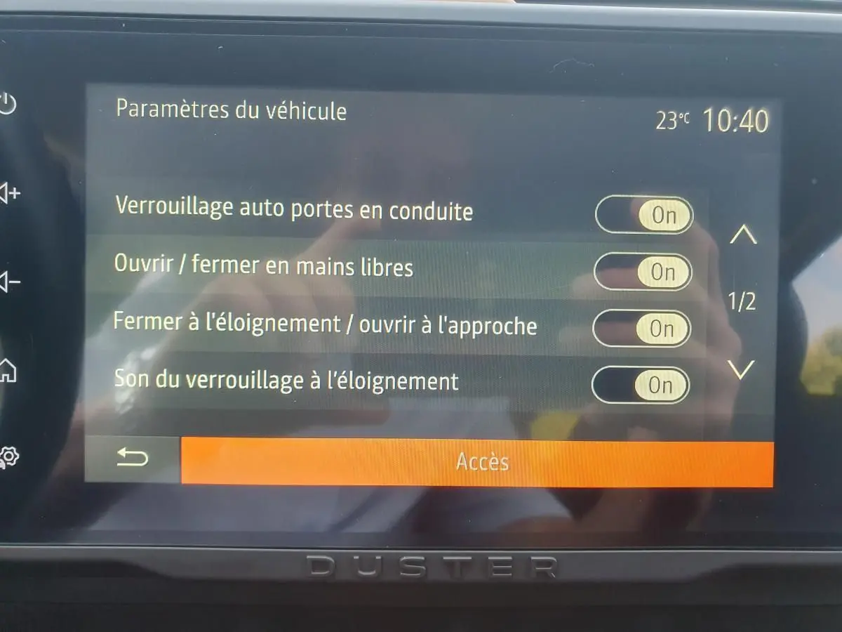 Écran tactile du tableau de bord du Dacia Duster 2023 affichant les réglages d'accès et verrouillage automatique.