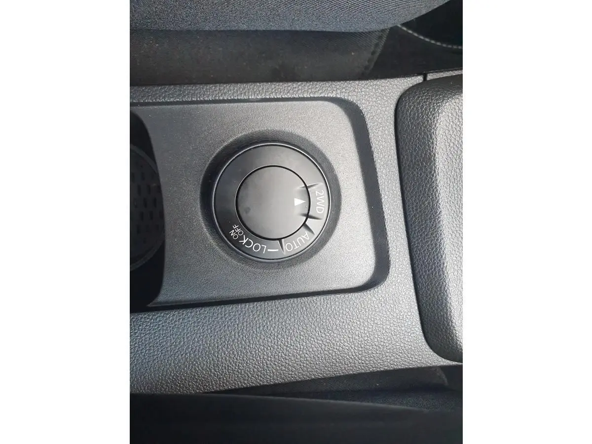Gros plan sur le sélecteur de mode 4x4 du Dacia Duster gris urbain, situé sur la console centrale.