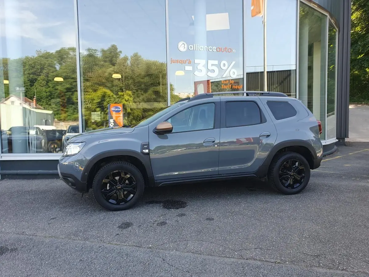 Profil droit du Dacia Duster 1.5 DCI 115 Extreme 4x4 gris urbain avec jantes noires et vitres surteintées.