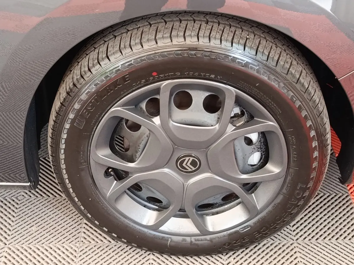 Gros plan sur la roue avant droite d’un Citroën Jumpy gris foncé, avec partie de l’aile visible.