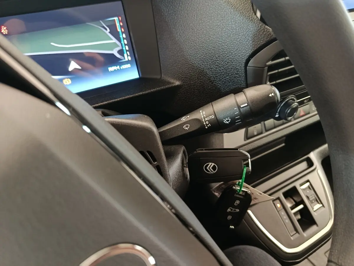 Vue intérieure rapprochée du volant noir d’un Citroën Jumpy 2025 avec clé insérée et écran de navigation allumé.