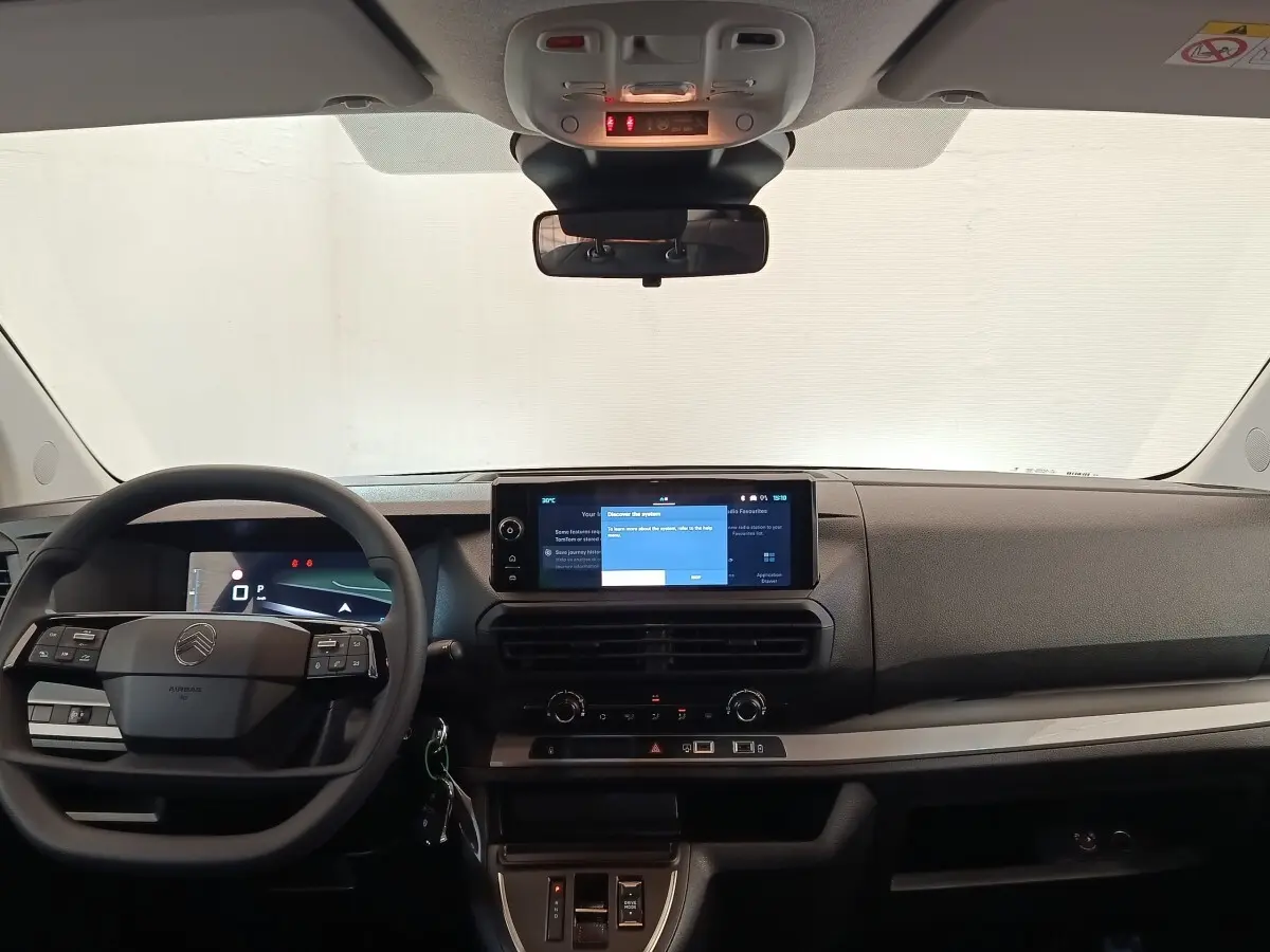 Vue frontale de l'habitacle gris foncé du Citroën Jumpy 2025, avec volant multifonctions et écran tactile central allumé.