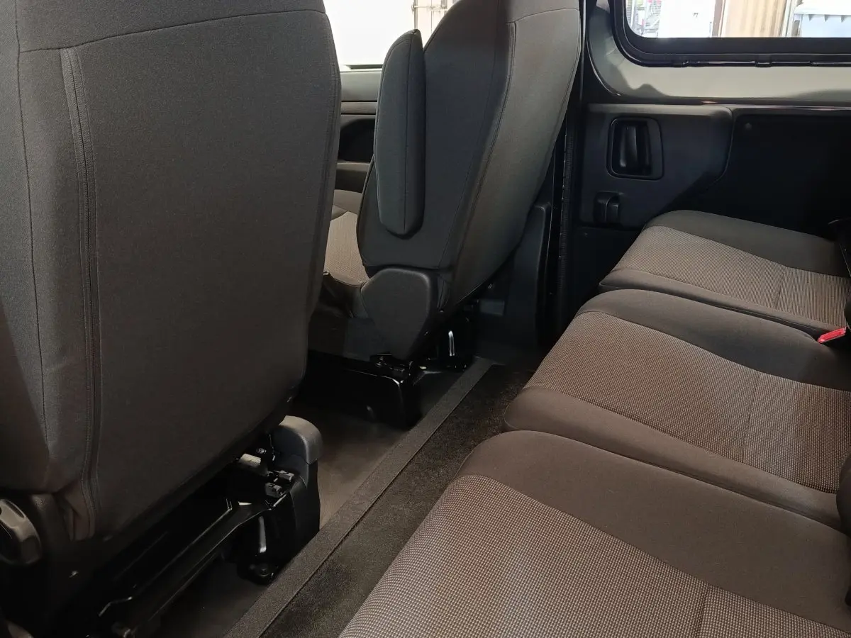 Vue intérieure du côté droit de la banquette arrière grise du Citroën Jumpy M Diesel 2025 avec sièges avant en tissu noir.