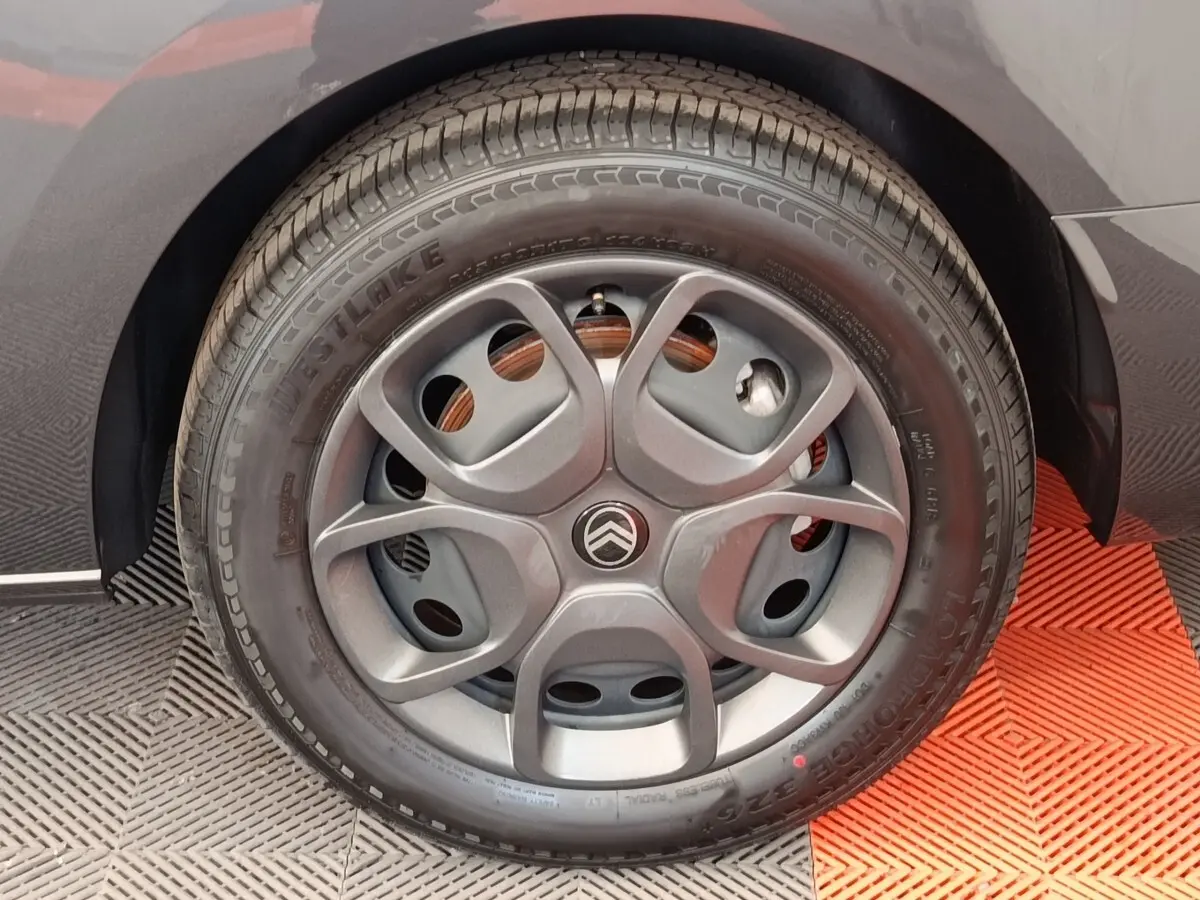 Gros plan sur la roue arrière droite d’un Citroën Jumpy gris foncé, avec partie de la carrosserie visible.