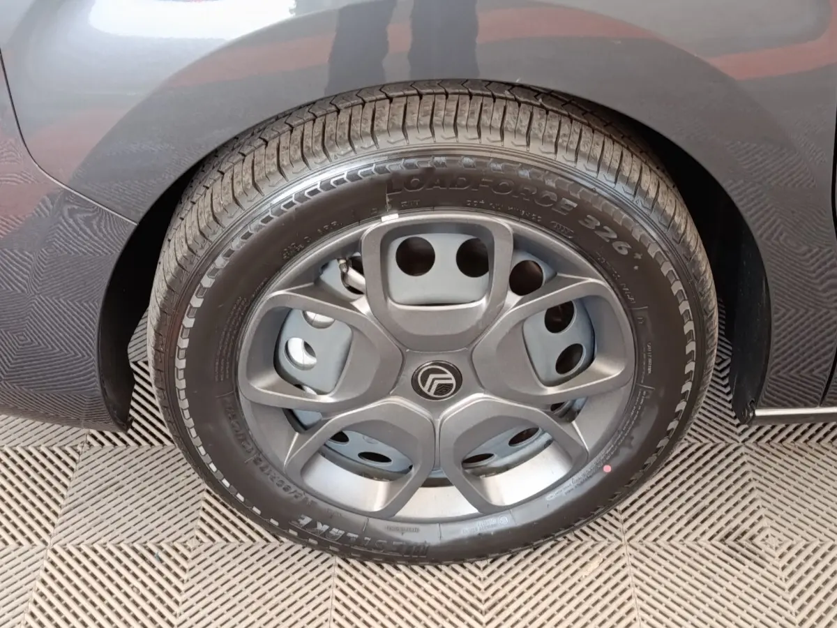 Gros plan sur la roue arrière droite du Citroën Jumpy gris foncé, montrant le pneu et l'aile du véhicule.