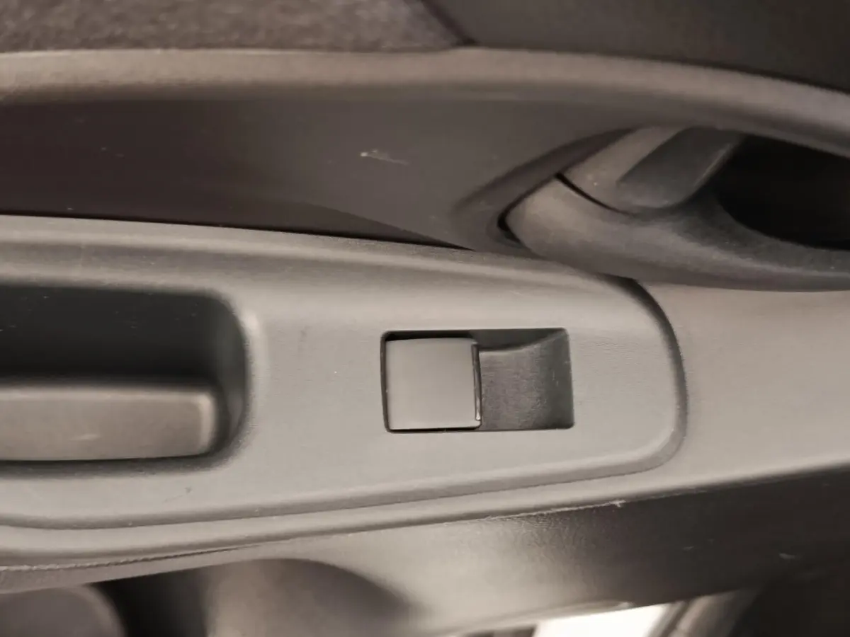 Détail du bouton de commande de la vitre côté gauche intérieur de la Toyota Yaris Cross blanche 2022 hybride.