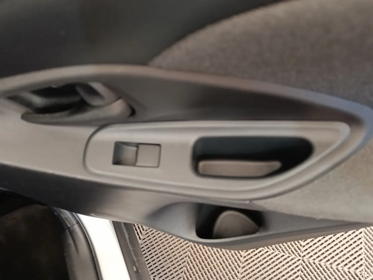 Détail de la poignée intérieure de porte arrière côté gauche de la Toyota Yaris Cross blanche 2022.
