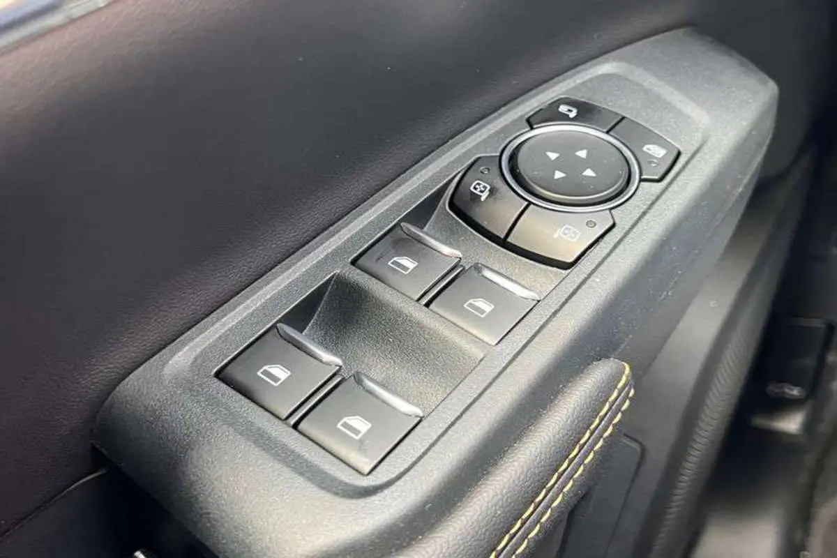 Gros plan sur les commandes de lève-vitres et réglage des rétroviseurs côté conducteur du Ford Ranger blanc 2026 Wildtrak Plus.
