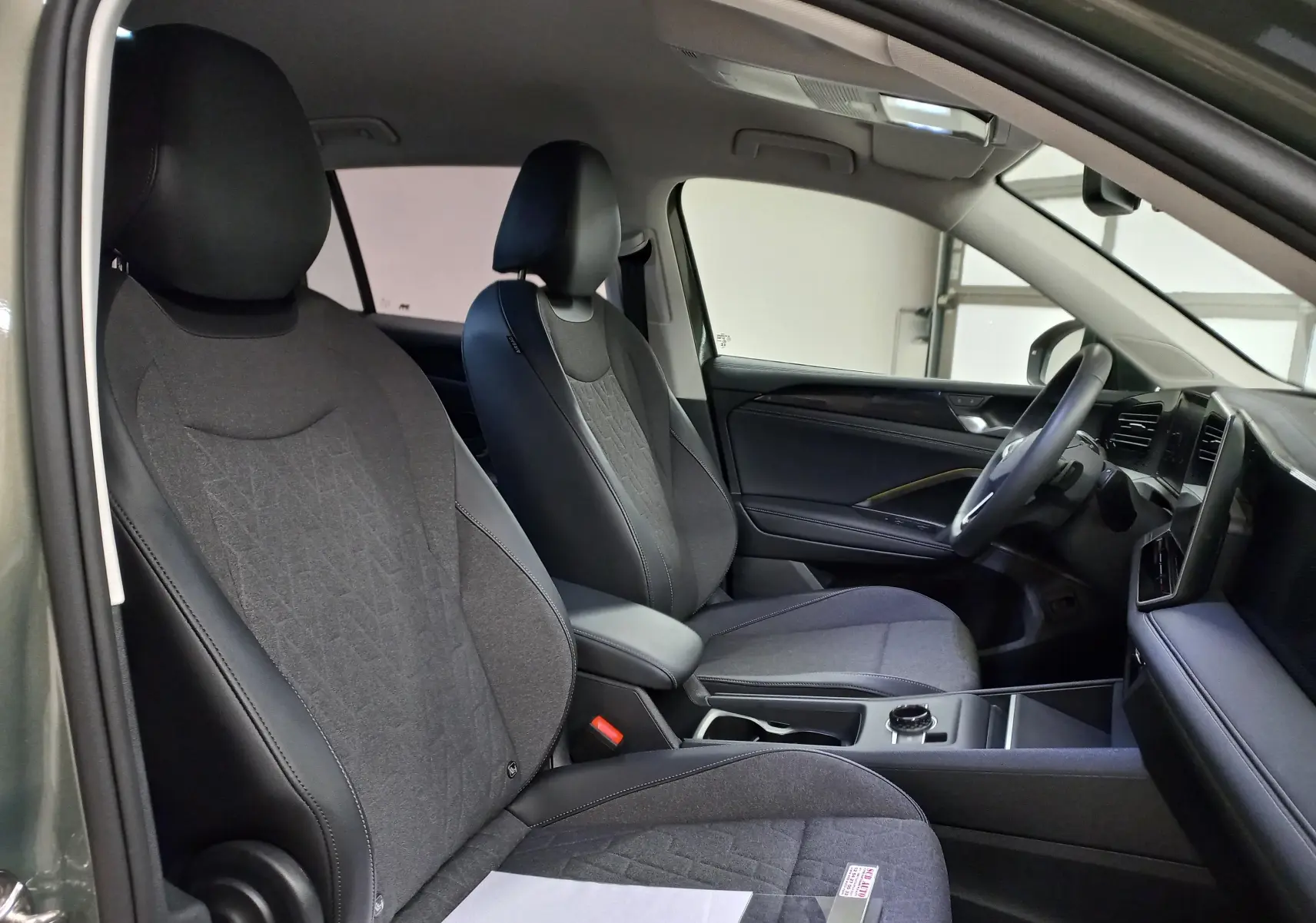 Intérieur du Volkswagen Tiguan 2025 vu côté conducteur, sièges tissu et cuir noir, tableau de bord moderne et épuré.