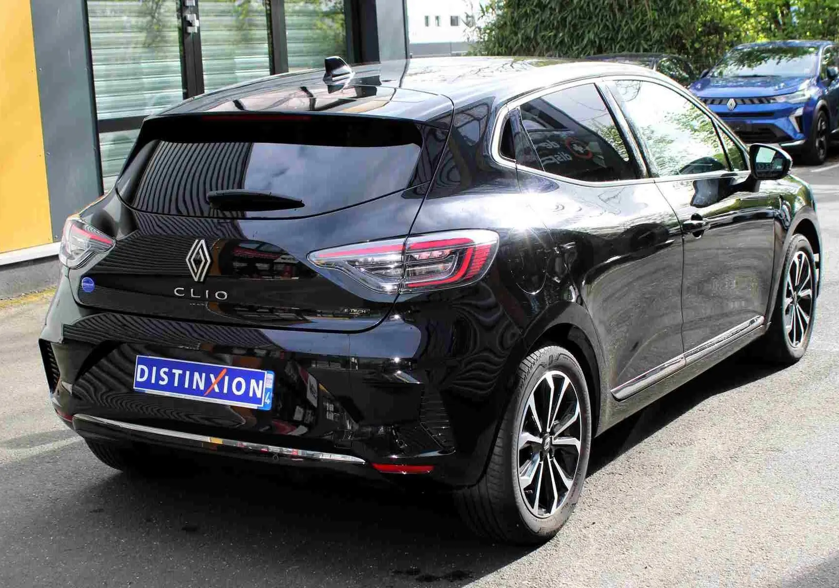Vue 3/4 arrière droite d'une Renault Clio noire étoile métal avec jantes alliage et vitres teintées.