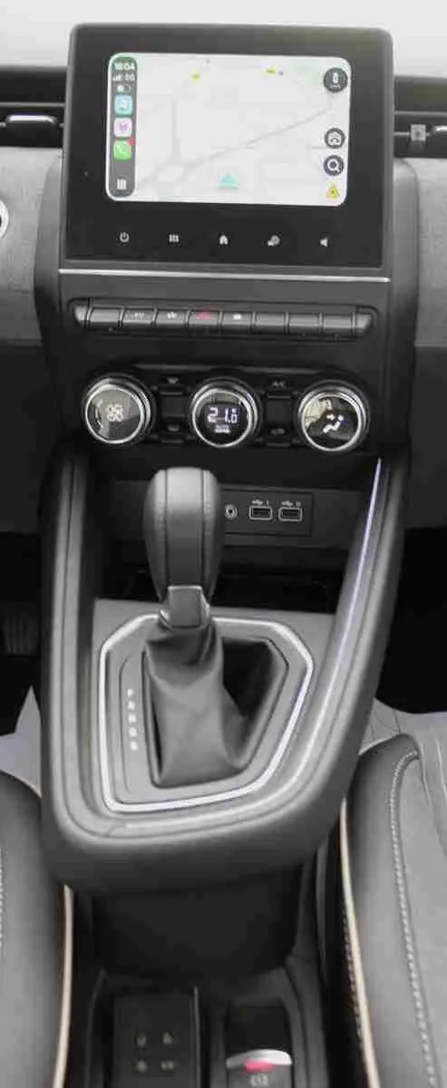 Vue centrée de la console centrale de la Renault Clio 2025 avec écran tactile, commandes climatisation et levier de boîte auto.