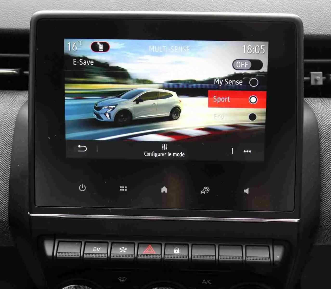 Écran tactile intérieur montrant une Renault Clio blanche en profil droit sur route, mode de conduite Sport sélectionné.