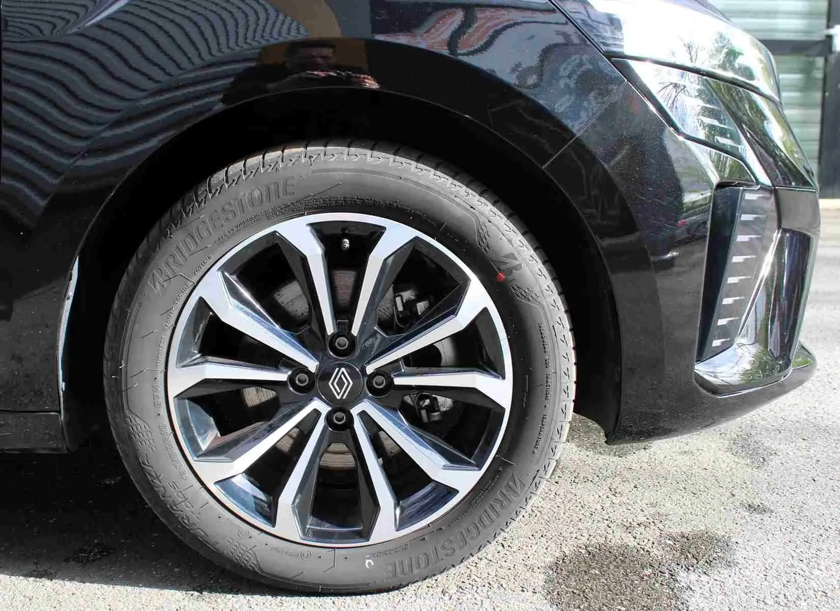 Gros plan sur la roue avant droite de la Renault Clio noire étoile métal, avec jante alliage au design moderne.