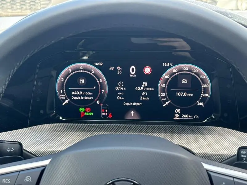 Vue rapprochée du tableau de bord numérique de la Volkswagen Golf gris lunaire, affichant vitesse et informations de conduite.