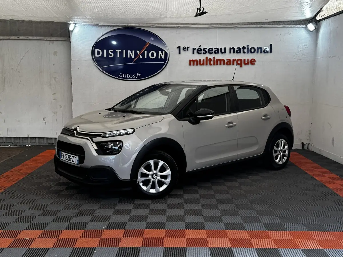 Citroën C3 beige vue 3/4 avant droit en intérieur, avec phares LED et jantes alliage visibles.