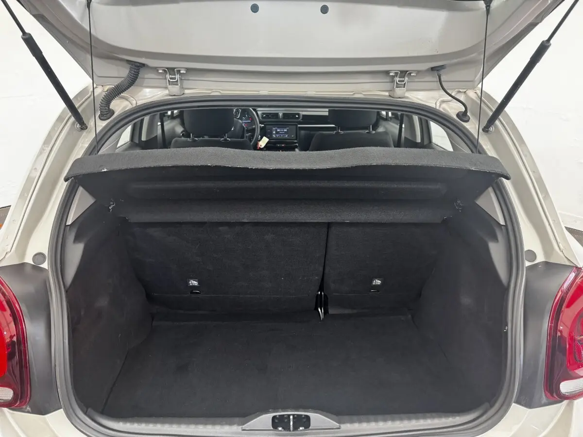 Coffre ouvert vue arrière d'une Citroën C3 beige 2021, montrant l'espace de chargement et l'intérieur noir.