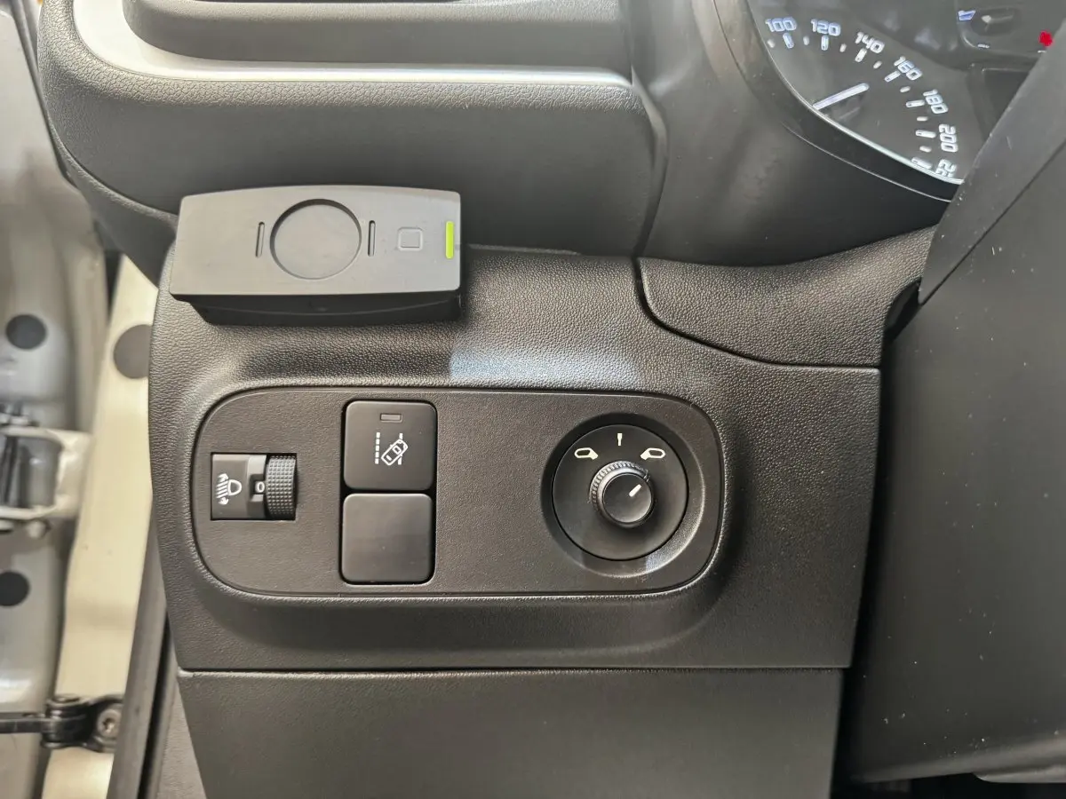 Vue rapprochée des commandes de réglage des phares et des rétroviseurs côté conducteur d'une Citroën C3 beige 2021.