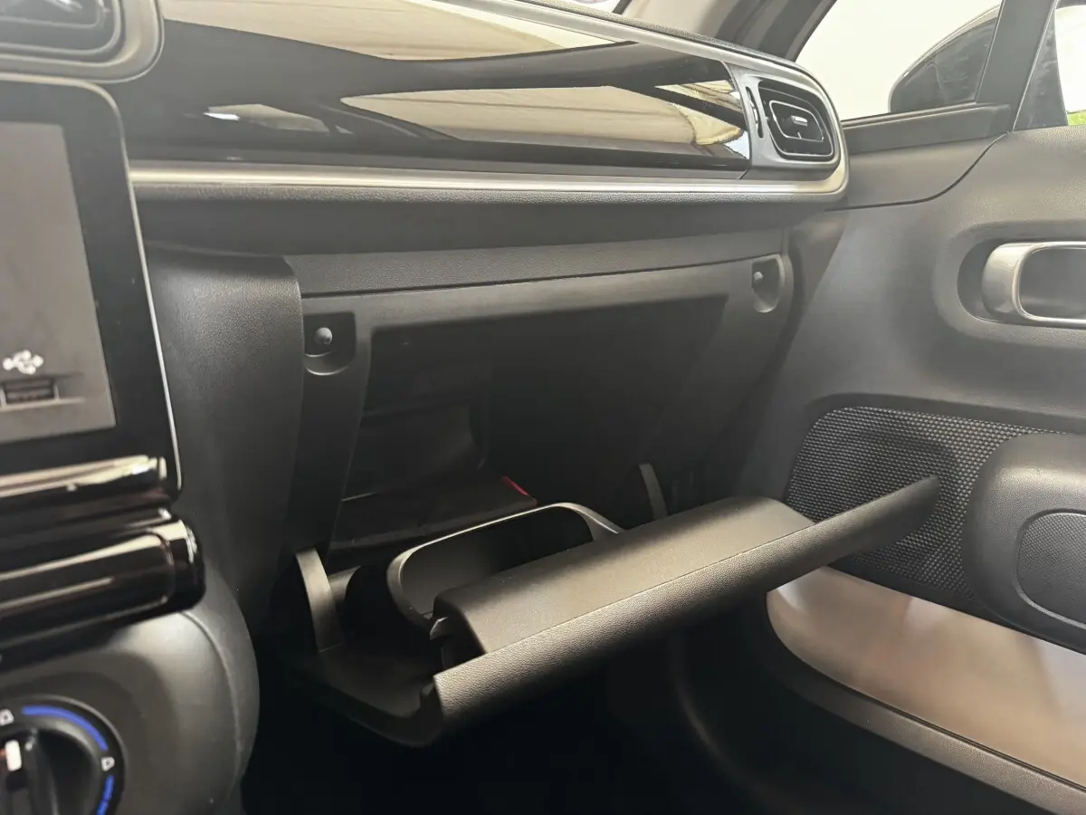 Intérieur de la Citroën C3 PureTech 83 S&S BVM Feel 2021, vue sur la boîte à gants ouverte côté passager.