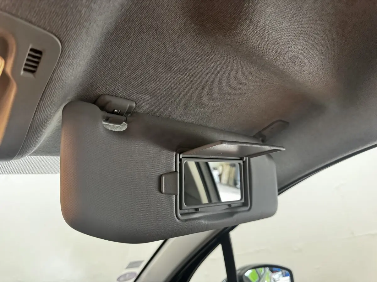 Détail du pare-soleil côté conducteur avec miroir de courtoisie ouvert dans une Citroën C3 beige 2021.