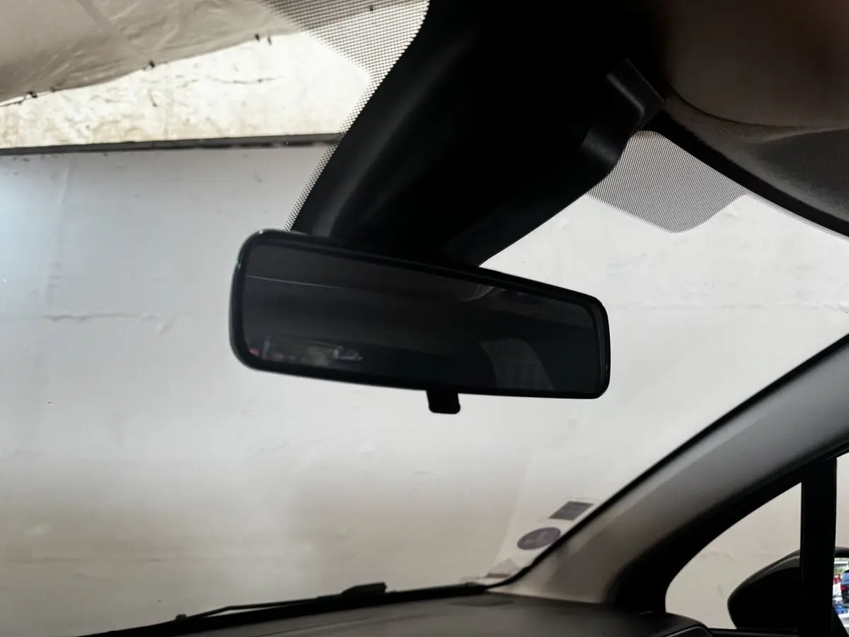 Rétroviseur intérieur noir de la Citroën C3 beige, vue depuis l’habitacle côté conducteur.