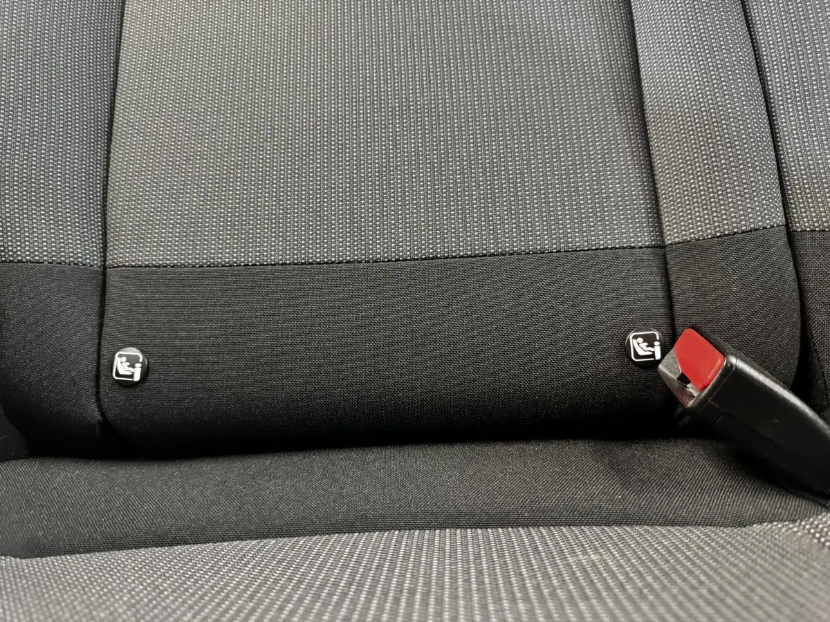 Détail de la banquette arrière noire et grise du Citroën C3 PureTech 83 S&S BVM Feel avec logos Isofix et boucle de ceinture rouge.