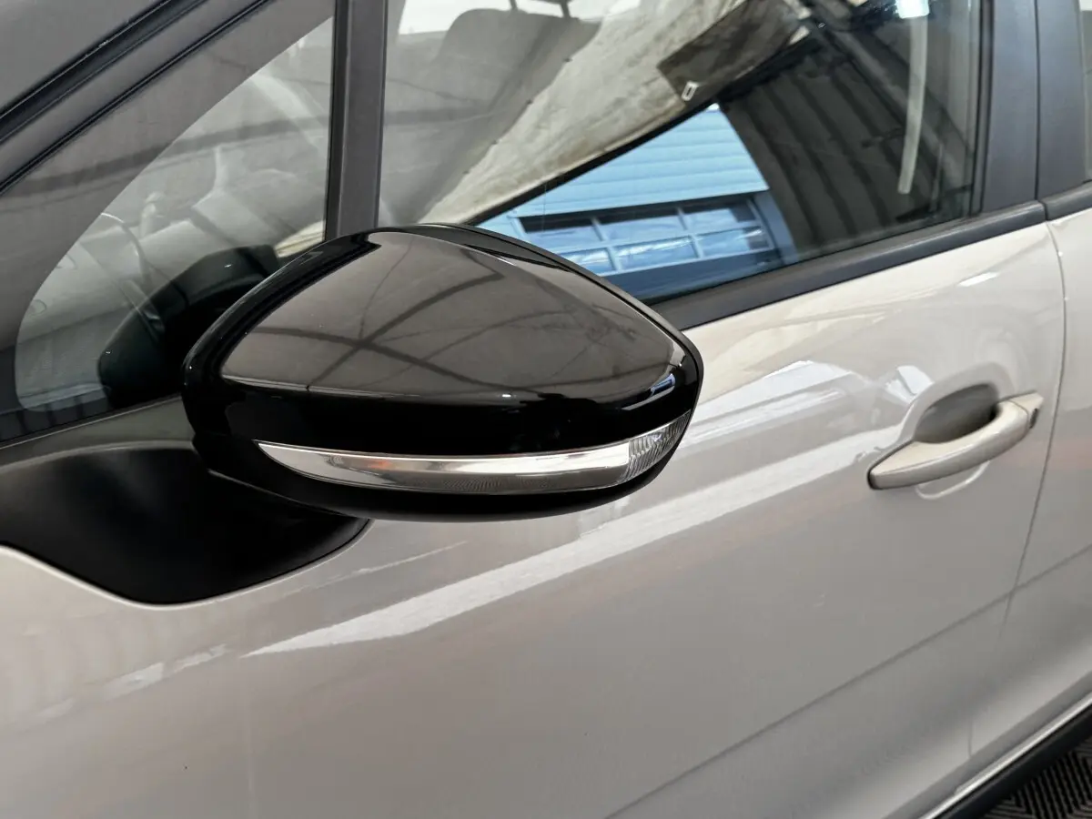 Gros plan sur le rétroviseur noir avec clignotant intégré côté conducteur d'une Citroën C3 beige 2021.