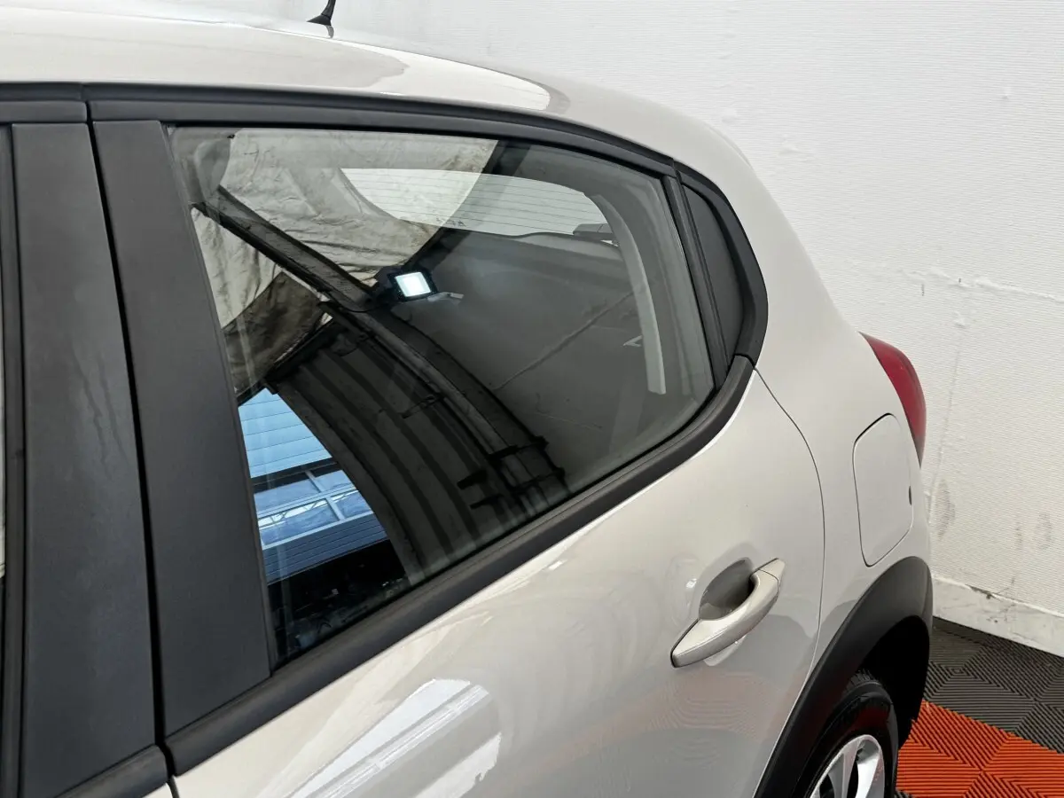 Vue rapprochée du côté arrière droit d'une Citroën C3 beige 2021, mettant en valeur la porte et la trappe à carburant.