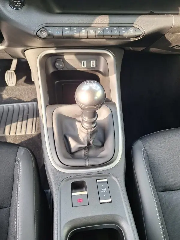 Vue rapprochée de la console centrale du Jeep Avenger 2025 avec levier de vitesse manuel et commandes électroniques.