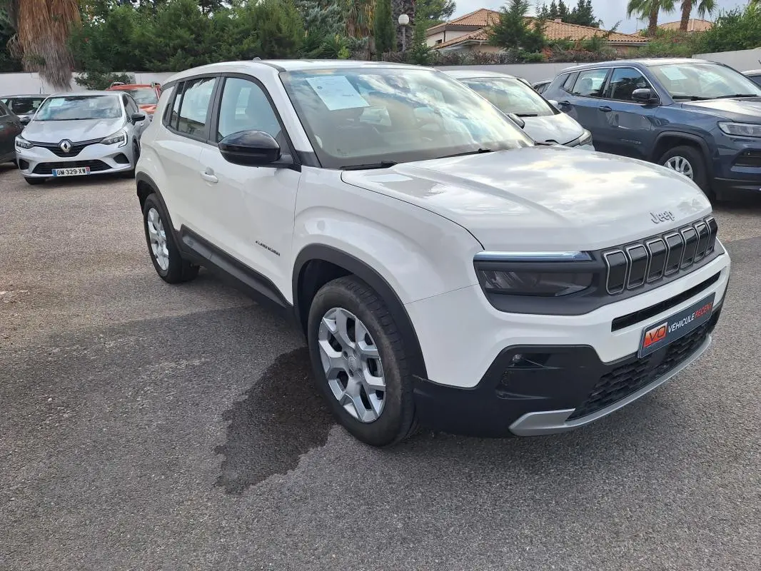 Jeep Avenger blanc vu en 3/4 avant droit, avec calandre noire distinctive et jantes alliage 17 pouces.