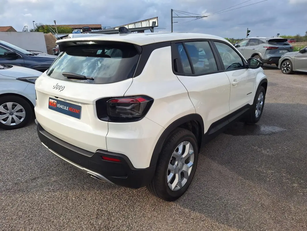 Jeep Avenger blanc en vue 3/4 arrière droit, avec jantes alliage 17 pouces et feux arrière teintés.