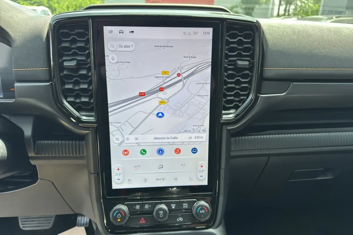 Vue centrée sur l'écran tactile vertical du tableau de bord du Ford Ranger bleu lightning, avec aérateurs hexagonaux noirs.